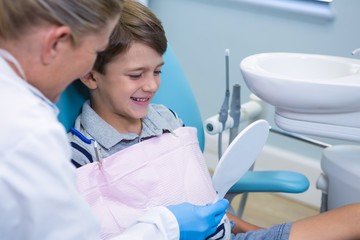 Dentist showing mirror to boy