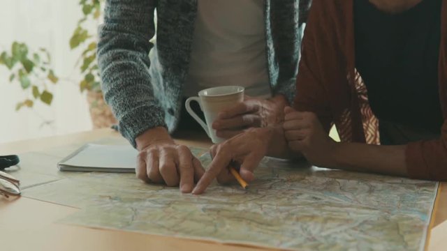 Senior couple with map at home, making plans.