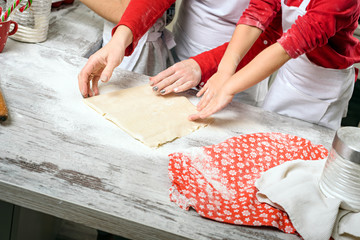 Mother with girls prepare dough for baking