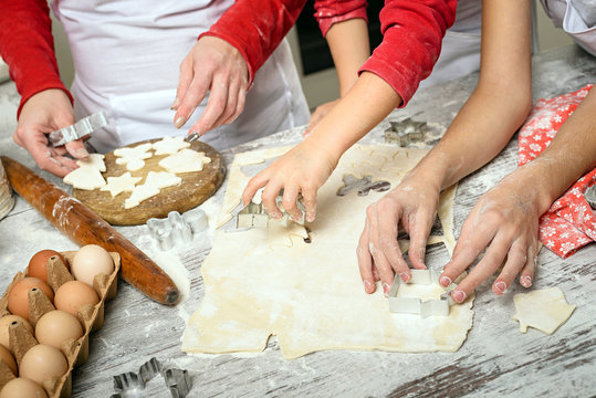 Mother with girls prepare dough for baking