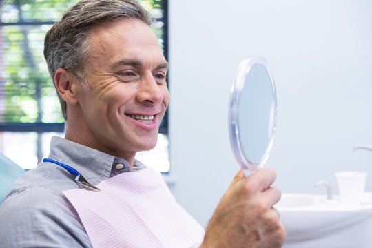 Portrait of smiling man looking in mirror