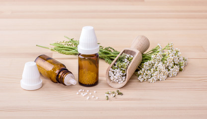 Homeopathic remedy / Homeopathic remedy with flowering yarrow and spoon with a wooden background