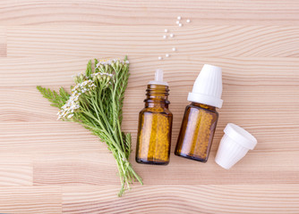 Homeopathic remedy / Top view of Homeopathic remedy with flowering yarrow with a wooden background