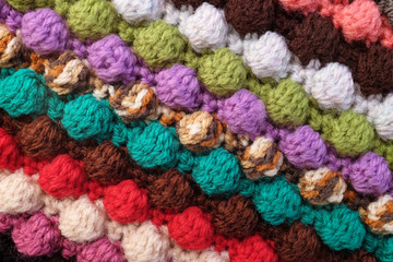 Fototapeta na wymiar Multi-coloured crochet bobble stitches diagonal stripes background