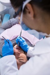 Doctor giving dental treatment to man at clinic