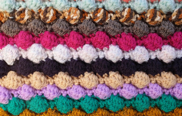 Horizontal multi-coloured stripes of bobble crochet stitches background
