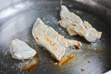 The meat is fried in a pan. chicken. Meat. The meat is frying. Electronic plate. Cooking. Kitchen. Tasty food. Close-up