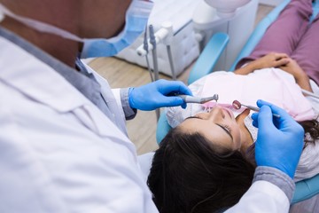 Fototapeta premium Close up of dentist examining woman mouth