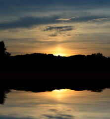 Naklejka premium Beautiful sunset over the lake and trees