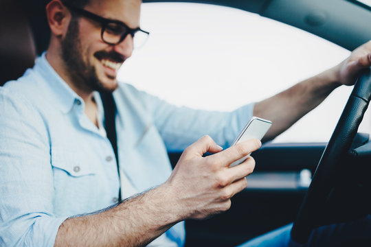 Man driver using smart phone in car modern