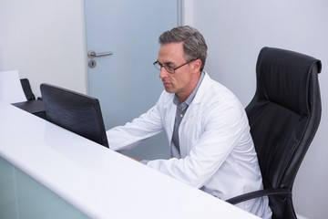 High angle view of dentist sitting by computer