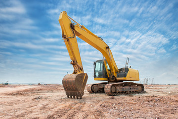 Heavy earth mover with blue sky in the background - obrazy, fototapety, plakaty