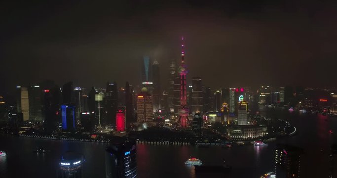 SHANGHAI, CHINA – JUNE 2016 : Aerial shot in Central Shanghai at night with Huangpu River, Shanghai Tower and TV Tower in view