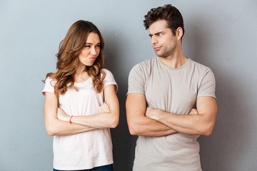 Upset disappointed couple standing with arms - obrazy, fototapety, plakaty
