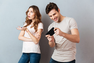 Portrait of a young couple standing with mobile phone