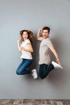 Full length portrait of an excited couple jumping