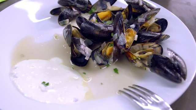 Mussels with white sauce on a plate.