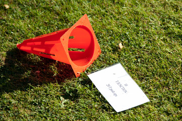Fitness Cone on its side on grass with note