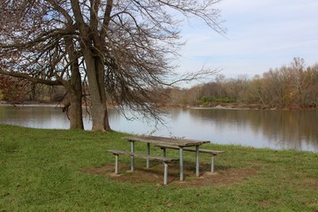 The empty picnic table by the river in the park.