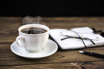 Notepad with pen, glasses, coffee on the table.The Business Concept .Copy space. selective focus.
