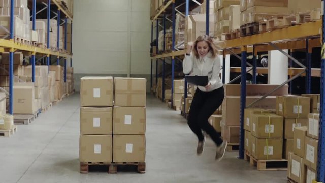 Overjoyed female worker or supervisor in a warehouse.