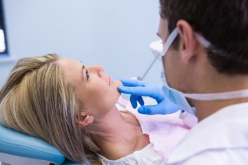 Obraz na płótnie Canvas Close up of dentist examining woman