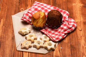 Composition of tiny gateau with sugar powder and cupcakes.