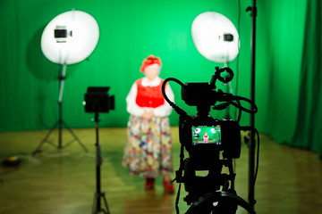 Obraz premium Actress in theatrical costume in a television Studio. Green screen and chroma key. Lighting equipment and filming equipment.