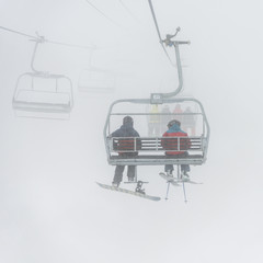 Tourists on ski lifts in foggy weather, Whistler, British Columbia, Canada