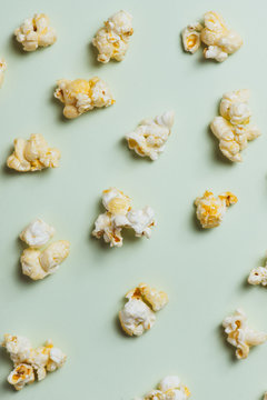 The popcorn in paper cup on green background.