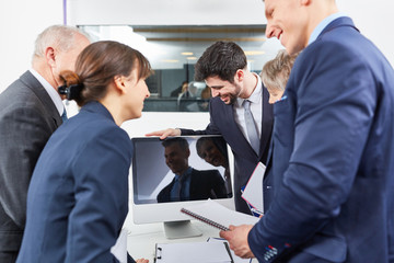 Geschäftsleute stehen um Computer Monitor im Büro