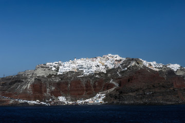 View of famous white buildings of Oia town on cliff in Santorini, Greece