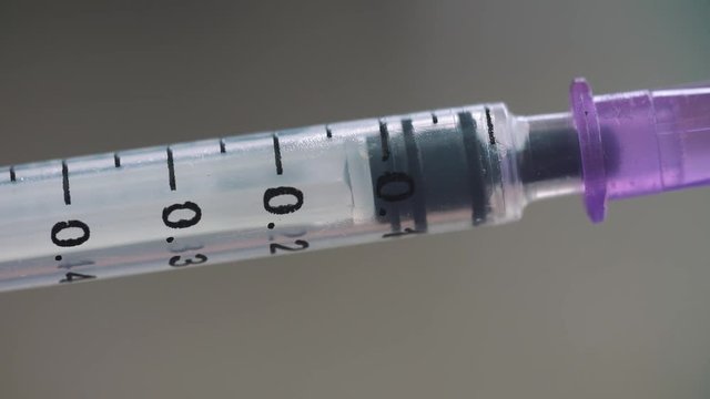 Medical syringe with drugs on blurry background