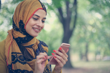 Muslim woman using smart phone.