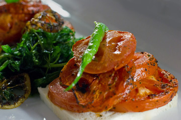 Baked tomato with baked vegetables and green pepper on a white bread. Selective focus