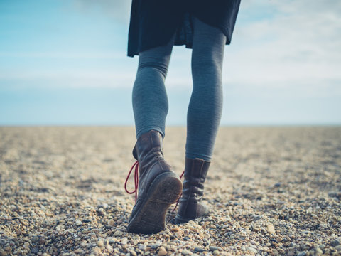 Legs of a woman walking on the beach in autumn