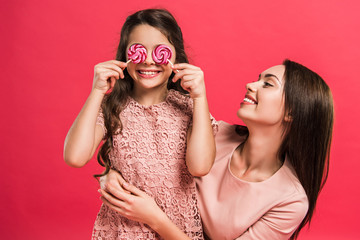 Daughter covering eyes with lollipops