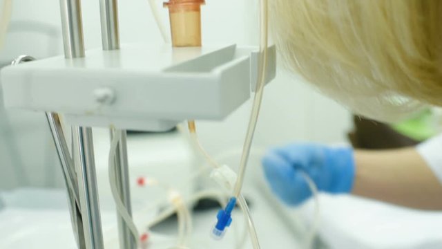 the doctor prepares the apparatus or equipment for plasmapheresis. Dropper, blood transfusion, plasma.