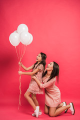 Daughter and mother looking at balloons