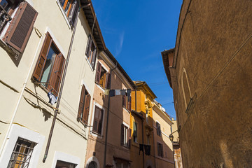 Fototapeta na wymiar Blue sky over a narrow alley in Rome