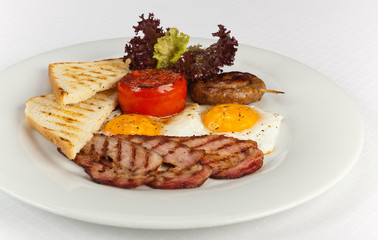 English Breakfast with toasts, sausages, grilled tomatoes ,egg, bacon and vegetables