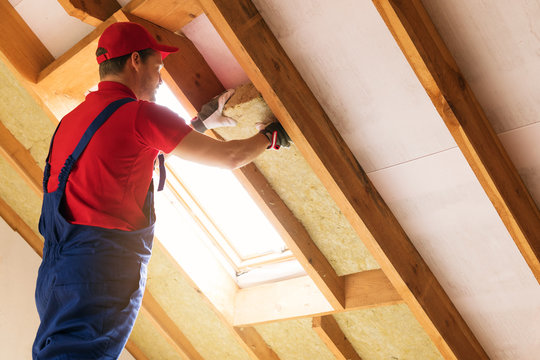 House Attic Insulation - Construction Worker Installing Rock Wool In Mansard Wall