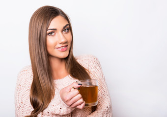 beautiful young girl enjoying warm cup of tea