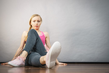 Woman in sportswear sitting on ground