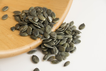 Green and organic healthy pumpkin seeds; peeled kernels of pumpkin on white background. Vegan and vegetarian super foods. Seeds and grains healthy diet.