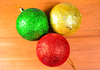 Three Christmas balls on wooden table
