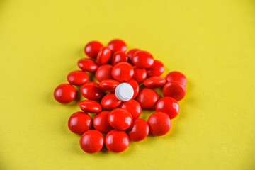 bright red pills on a yellow background.