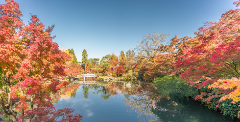Beautiful autumn colors, Fall foliage and gorukaku stone bridge across the Hojo-ike pond to Benten shrine. Eikan-do Zenrin-ji temple. Kyoto, Japan