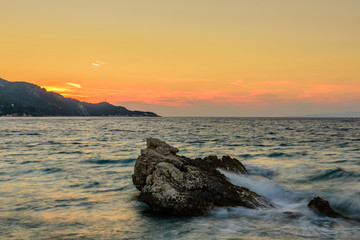 Beautiful sunset on the sea. The picturesque beach in Kokkari village, Samos island, Greece.