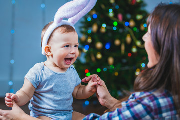 Portrait of a happy child and a woman near a Christmas tree